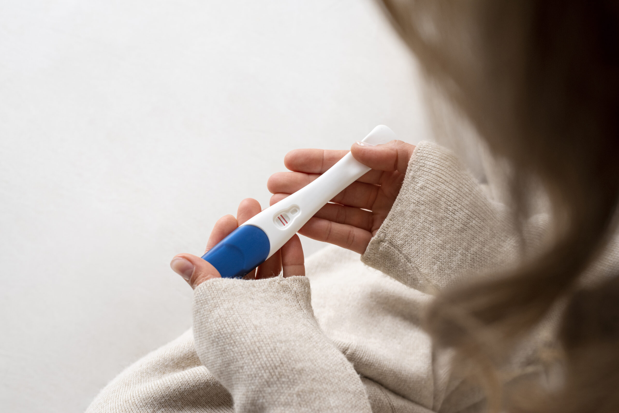 side-view-woman-holding-positive-pregnancy-test